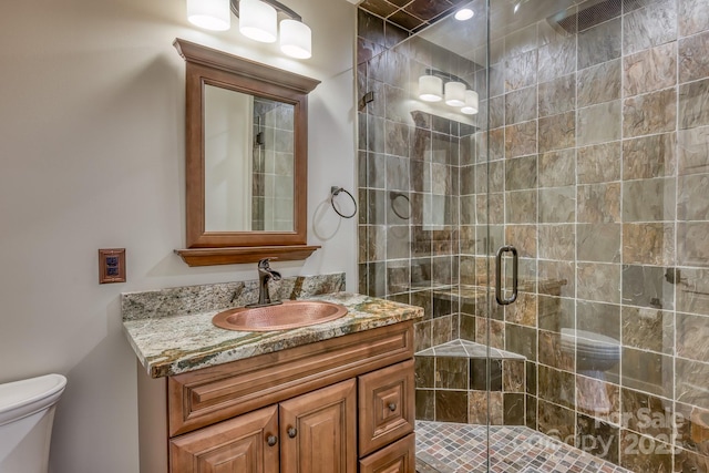 bathroom featuring vanity, toilet, and walk in shower