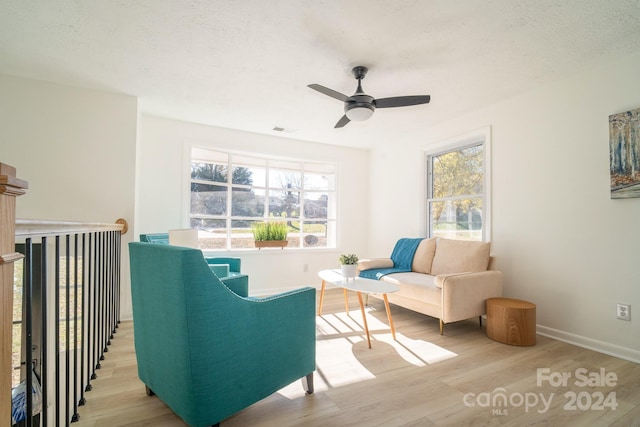 living area featuring ceiling fan, a healthy amount of sunlight, and light wood-type flooring