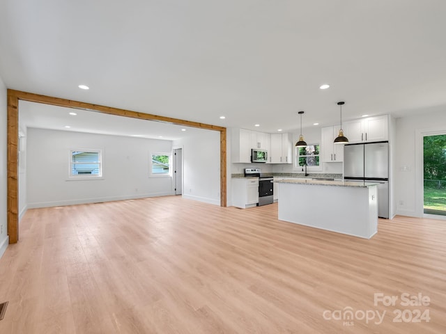 kitchen with pendant lighting, a center island, white cabinetry, and appliances with stainless steel finishes