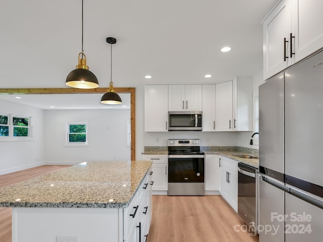 kitchen featuring a center island, sink, white cabinetry, and stainless steel appliances