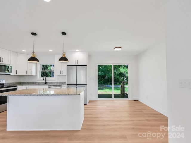 kitchen featuring white cabinets, a center island, and stainless steel appliances