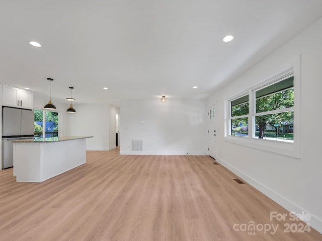 unfurnished living room with a wealth of natural light and light hardwood / wood-style flooring