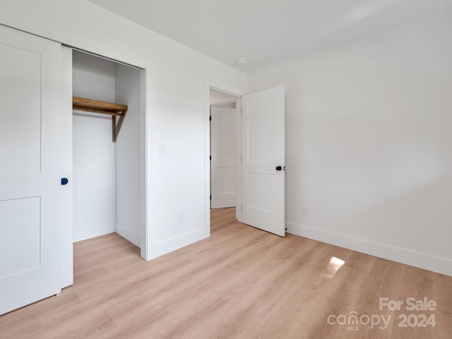 unfurnished bedroom featuring a closet and light hardwood / wood-style floors