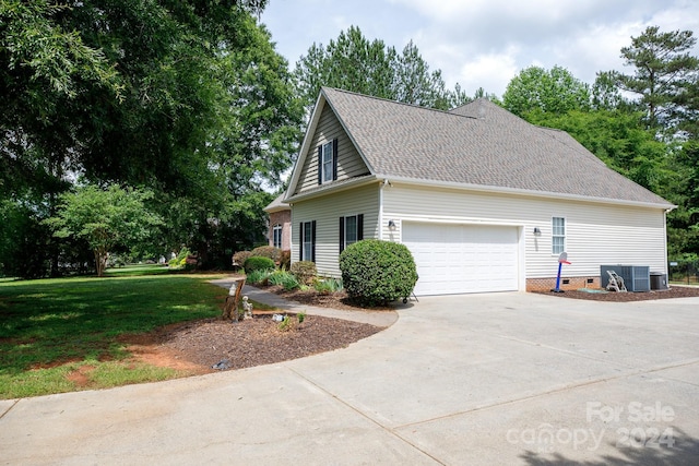 view of property exterior featuring central AC, a yard, and a garage