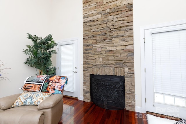 living area with dark hardwood / wood-style floors and a fireplace