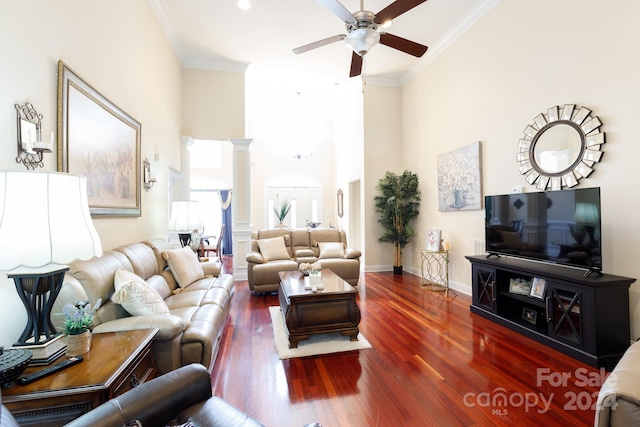 living room featuring crown molding, dark wood-type flooring, and a high ceiling