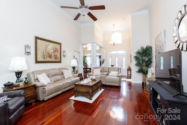 living room featuring ceiling fan with notable chandelier, a high ceiling, dark hardwood / wood-style floors, and ornamental molding