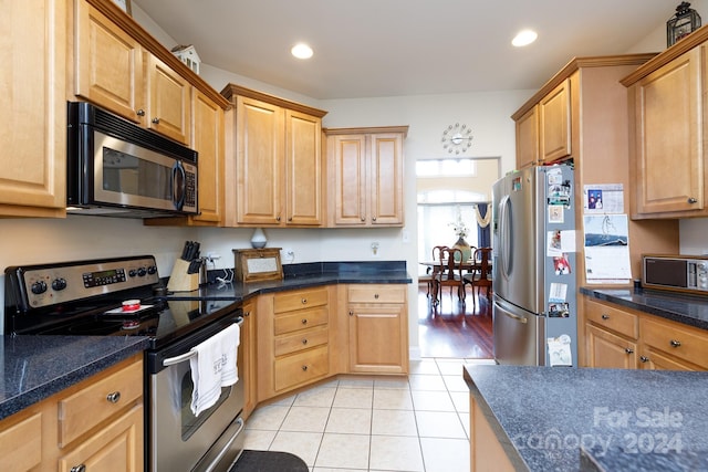 kitchen with light tile patterned flooring and stainless steel appliances