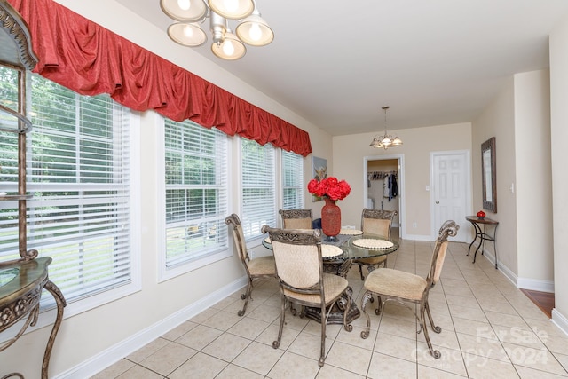 tiled dining room featuring a notable chandelier