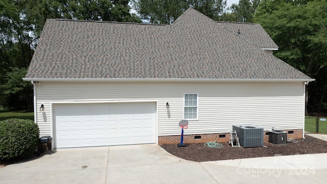 view of side of property featuring a garage and cooling unit