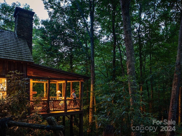 view of home's exterior with a deck and a sunroom