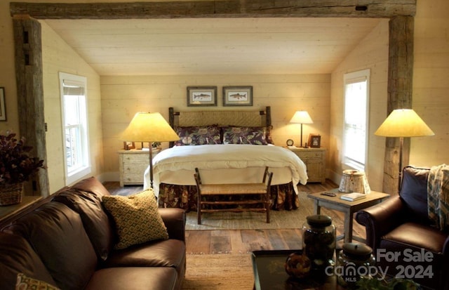 bedroom featuring hardwood / wood-style flooring, vaulted ceiling, and multiple windows