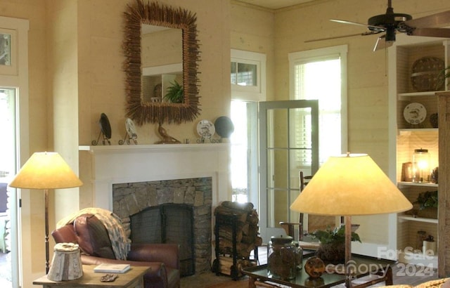 sitting room with ceiling fan and a fireplace