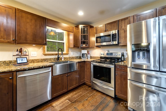 kitchen with light stone countertops, stainless steel appliances, dark wood-type flooring, and sink