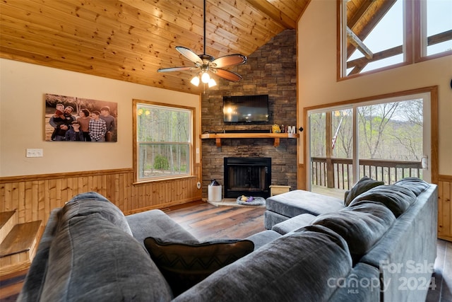 living room with hardwood / wood-style floors, high vaulted ceiling, ceiling fan, a fireplace, and wood ceiling