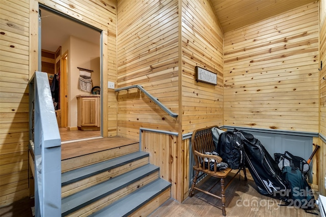 stairs featuring wood walls