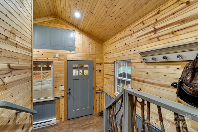 interior space featuring baseboard heating, wood-type flooring, lofted ceiling, wooden walls, and wood ceiling