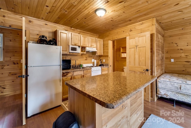 kitchen featuring a center island, wooden ceiling, white appliances, wooden walls, and light brown cabinetry