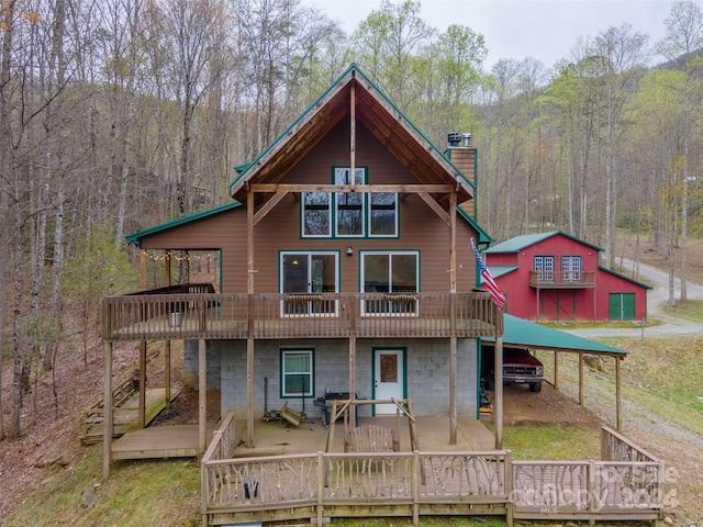 rear view of property with a carport and a deck