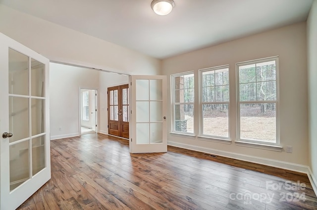 unfurnished room with hardwood / wood-style flooring and french doors