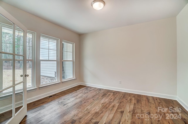 spare room featuring hardwood / wood-style floors and plenty of natural light