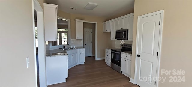 kitchen featuring white cabinets, dark hardwood / wood-style floors, stone countertops, sink, and stainless steel appliances