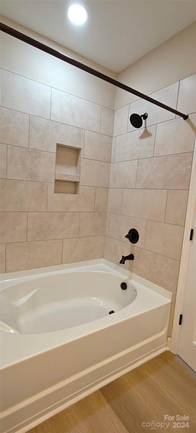 bathroom with tiled shower / bath and hardwood / wood-style floors