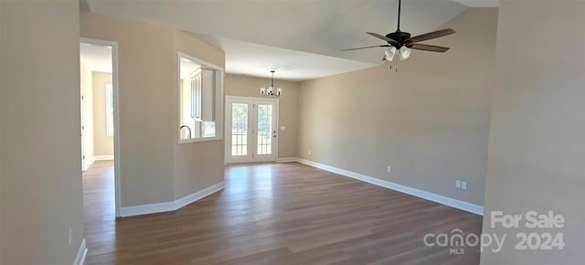 unfurnished room featuring french doors, hardwood / wood-style flooring, and ceiling fan with notable chandelier