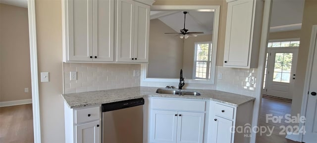 kitchen featuring white cabinetry, tasteful backsplash, stainless steel dishwasher, and vaulted ceiling