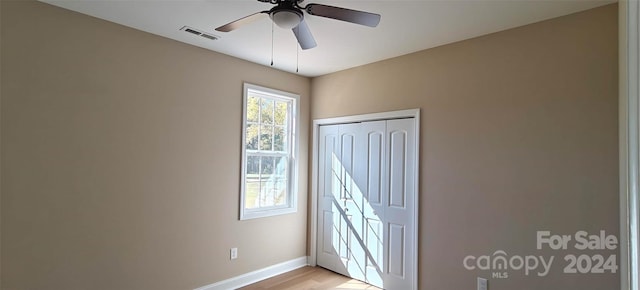 unfurnished bedroom with light hardwood / wood-style flooring, a closet, and ceiling fan