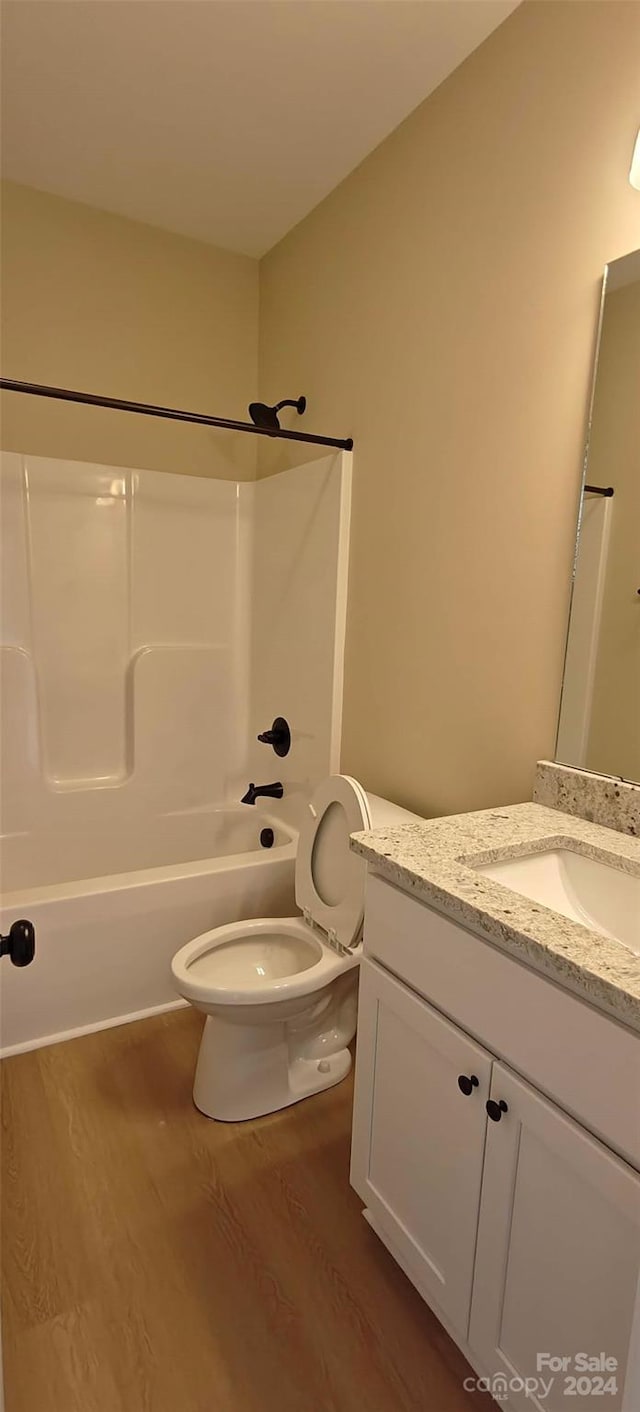 full bathroom featuring vanity, toilet, and wood-type flooring