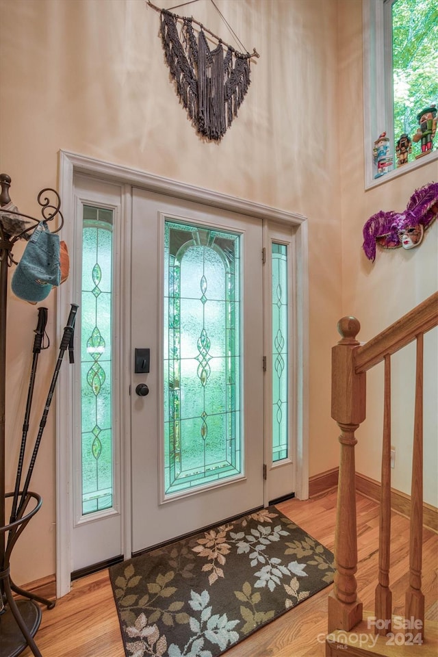 entrance foyer with light hardwood / wood-style flooring and a towering ceiling