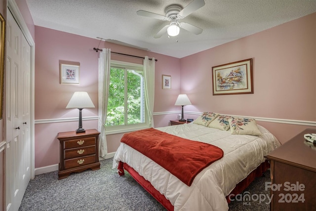 carpeted bedroom with a textured ceiling, a closet, and ceiling fan