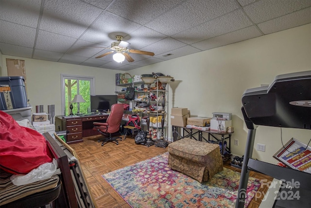 home office with a paneled ceiling, ceiling fan, and parquet floors