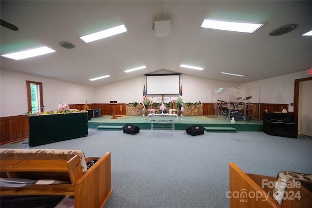 miscellaneous room with carpet floors, wooden walls, and lofted ceiling