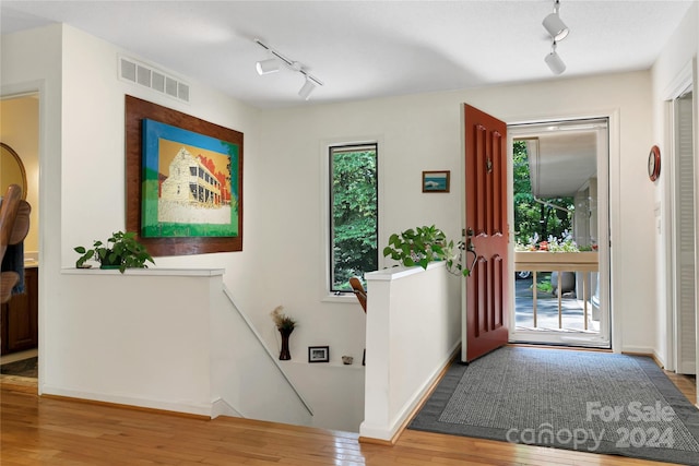 foyer with hardwood / wood-style flooring and track lighting