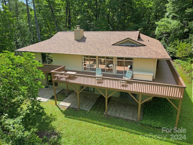 back of house featuring a deck, a patio area, and a yard