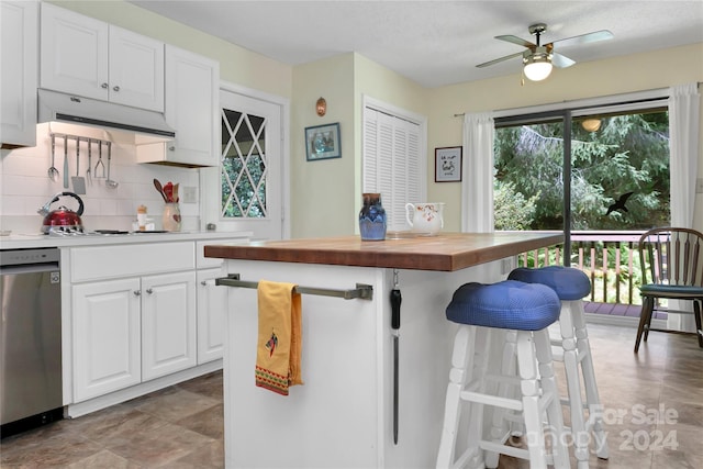 kitchen featuring butcher block counters, ceiling fan, backsplash, stainless steel dishwasher, and white cabinets