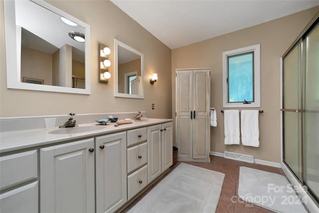 bathroom with walk in shower, vanity, and tile patterned flooring