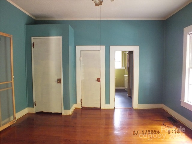 spare room featuring dark hardwood / wood-style flooring and crown molding