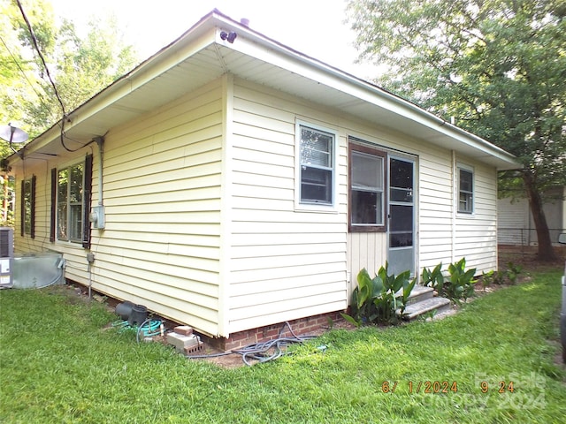 view of side of home with a lawn