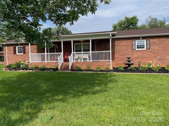 single story home featuring covered porch and a front yard