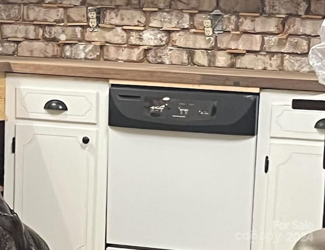 interior details featuring white dishwasher and white cabinetry