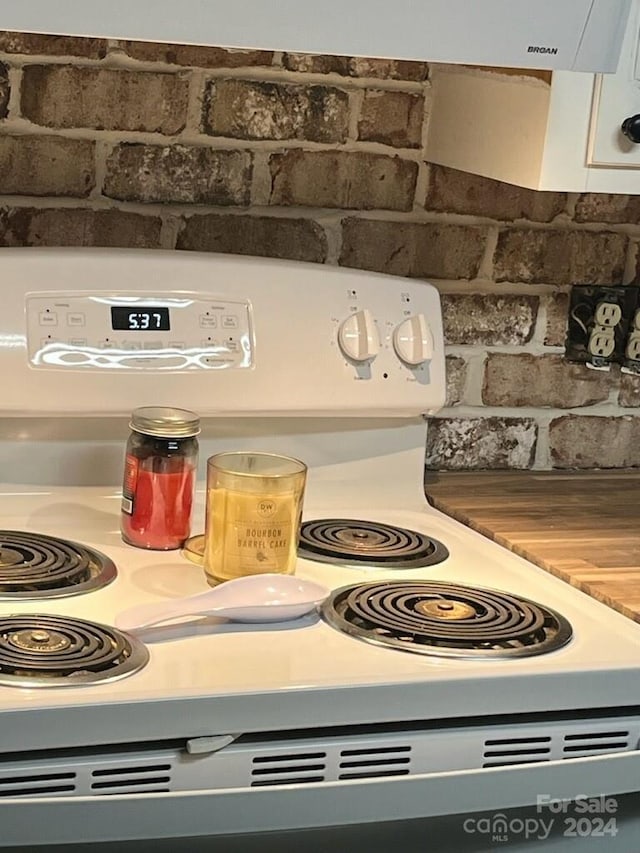 details featuring white cabinets and white electric stove