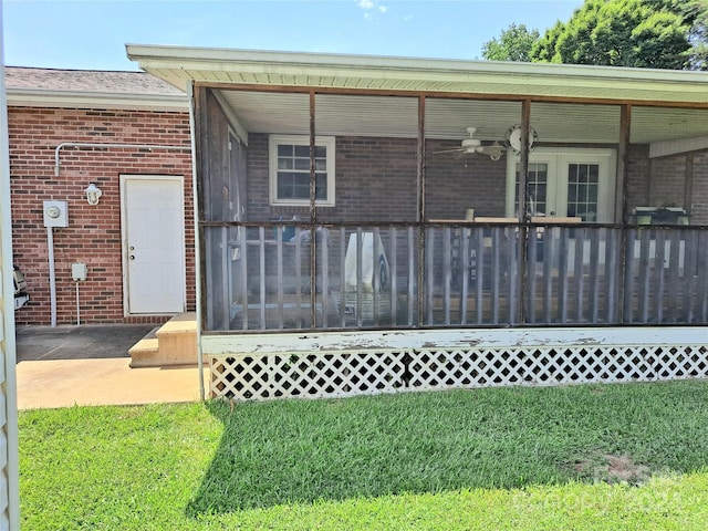 exterior space with ceiling fan and a yard