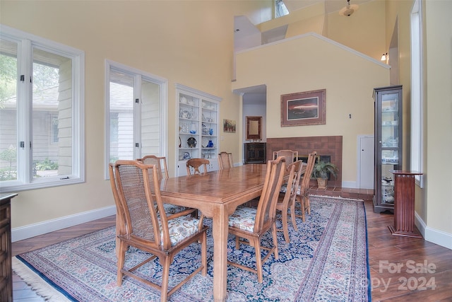 dining space featuring a towering ceiling and dark hardwood / wood-style flooring