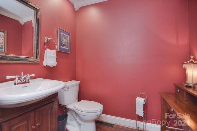 bathroom with hardwood / wood-style floors, toilet, vanity, and crown molding