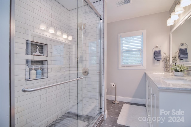 bathroom featuring tile patterned floors, vanity, and an enclosed shower