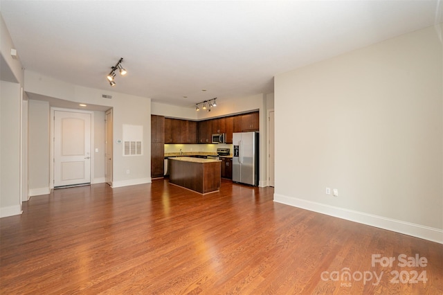 kitchen with dark hardwood / wood-style flooring, a center island, stainless steel appliances, and dark brown cabinets