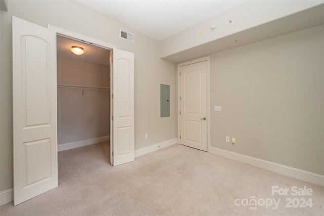 unfurnished bedroom featuring electric panel and light carpet